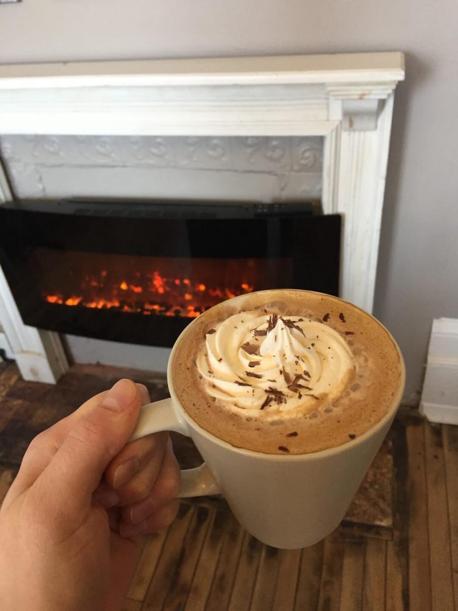 Enjoying a cup by the fire at Creative Grounds Cafe in Miramichi