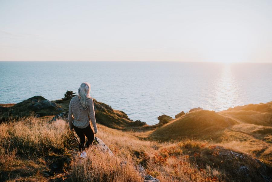 a girl walking on the fundy coast during sunset