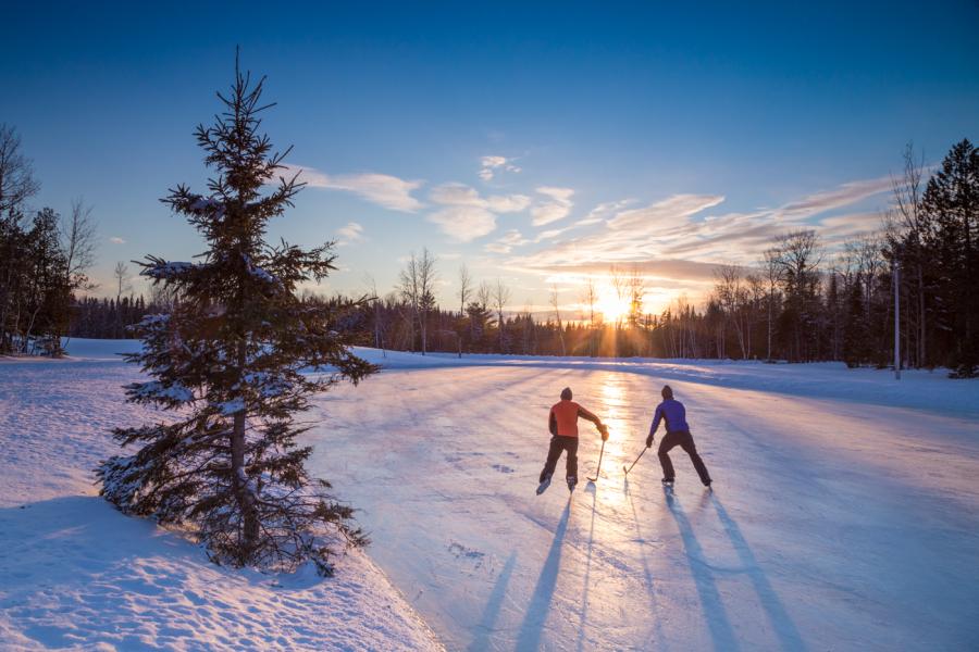 two people skating on a pond