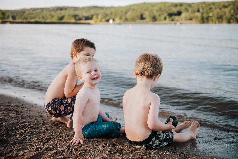 three kids sitting in the water at mactaquac