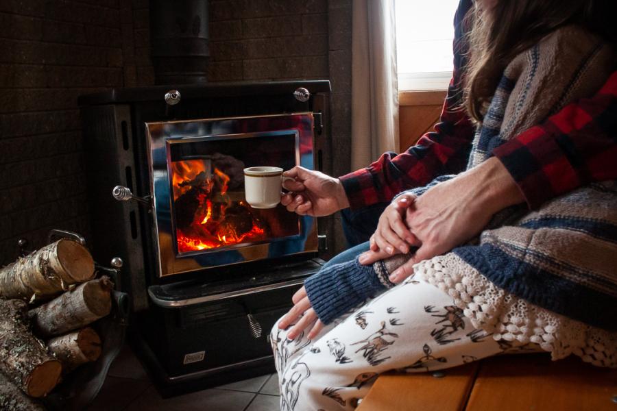 Warming up by the stove at Chalets Restigouche, Kedgwick