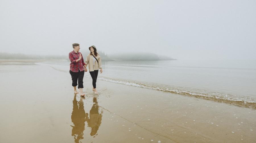 two ladies walking on the beach in the surf