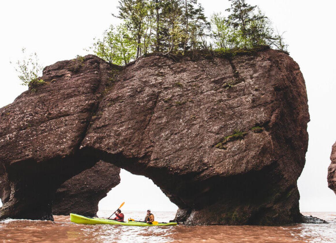 Tiny kayaks under the giant rocks