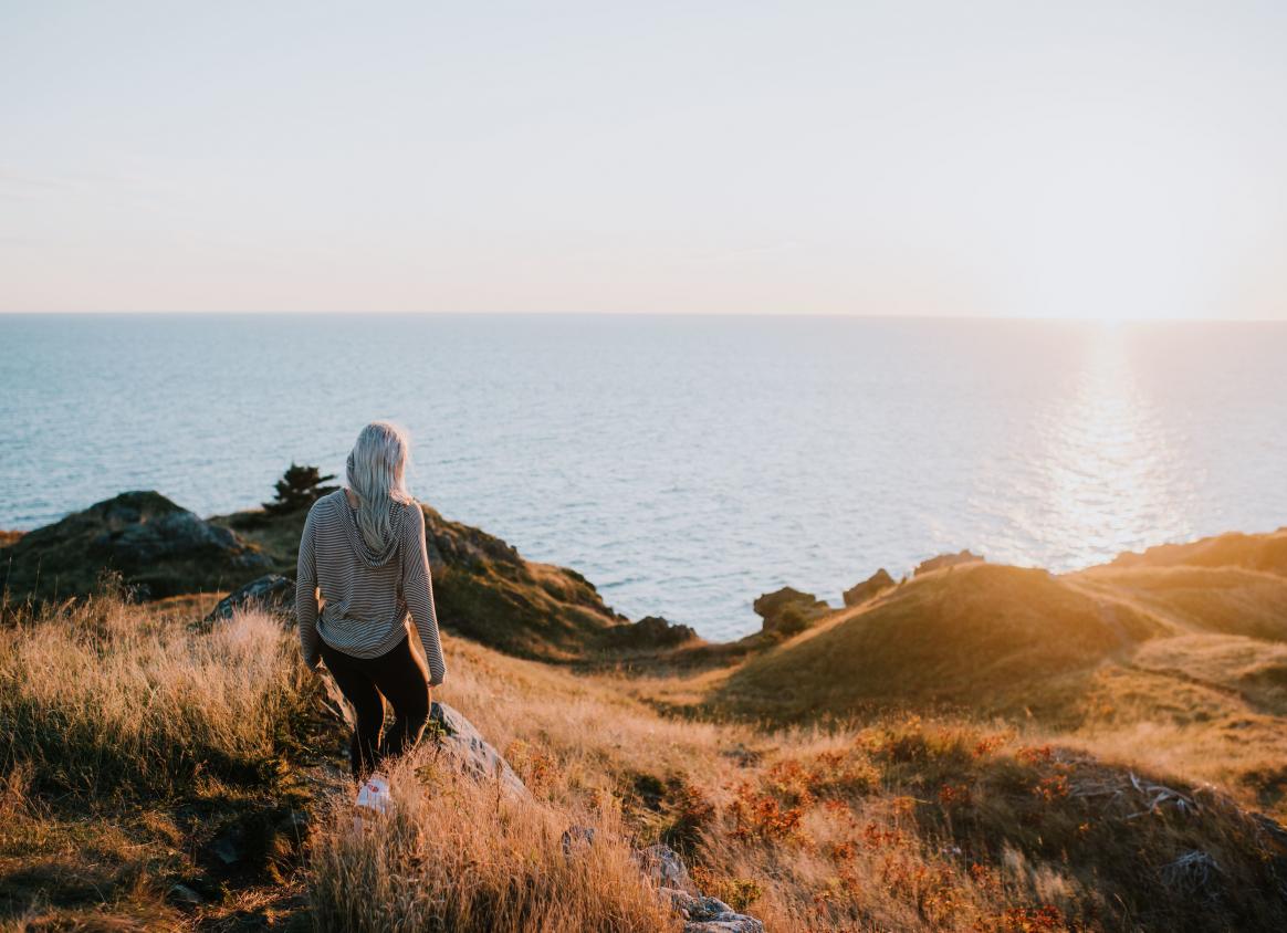 a girl walking on the fundy coast during sunset